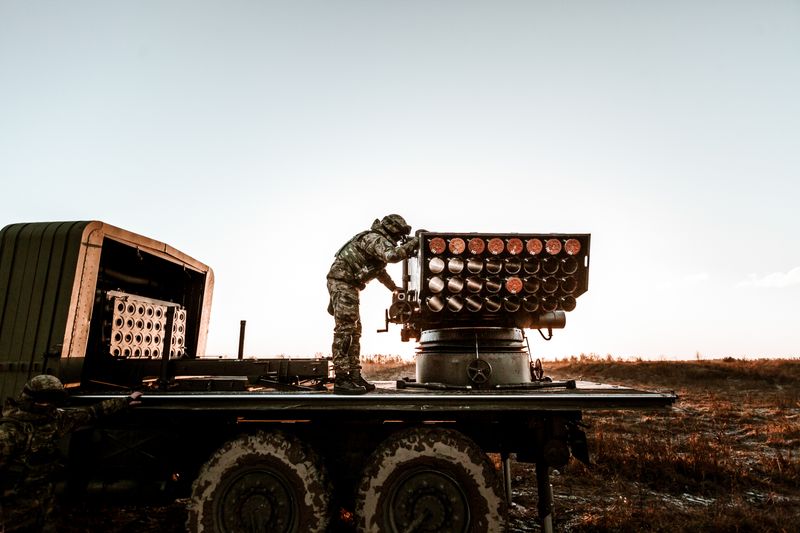 A soldier adjusting equipment on a military truck