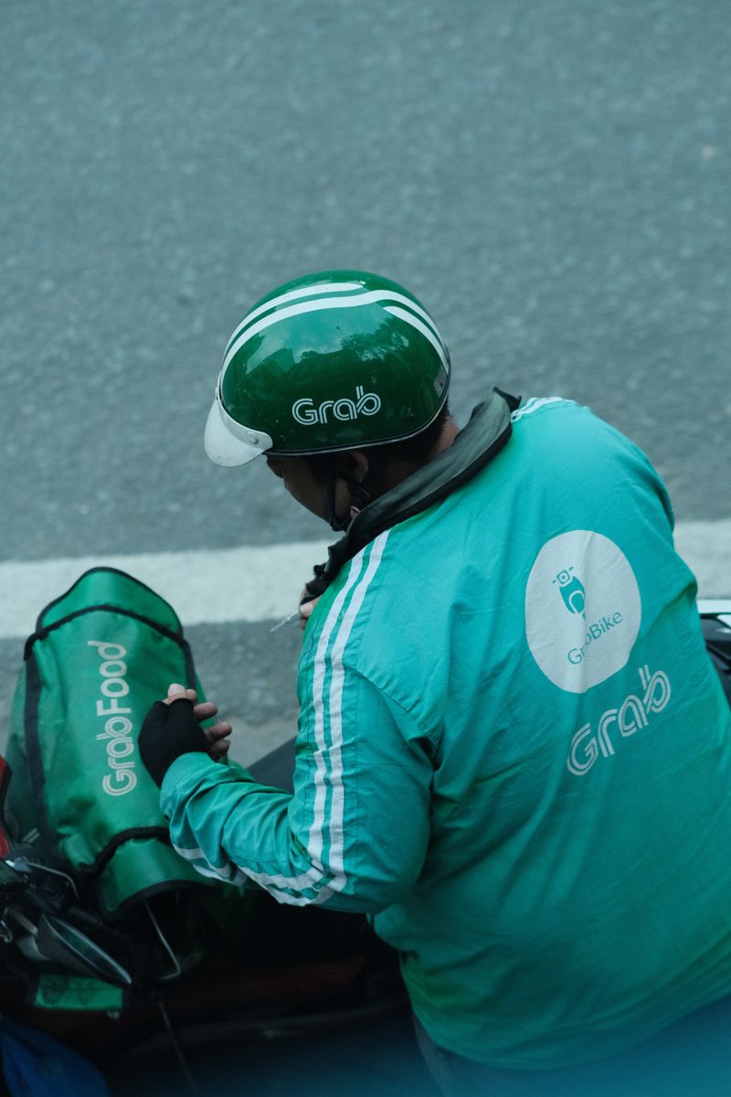 A delivery rider preparing for a delivery on a city street