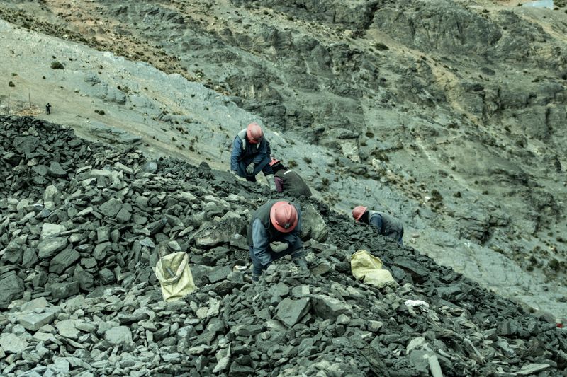 A crew with helmets collecting stones in a quarry