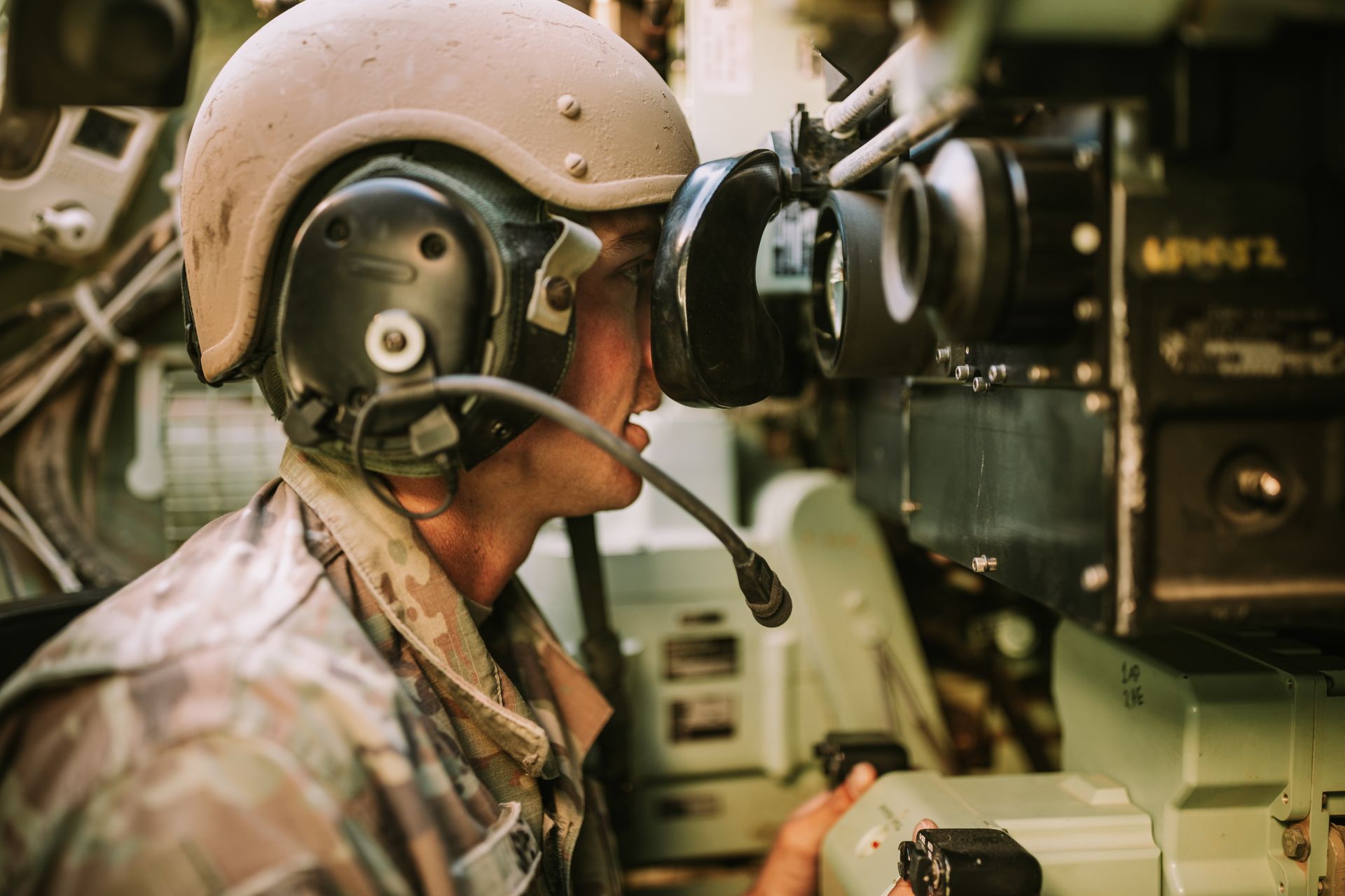 A specialist operating modern military equipment inside a vehicle