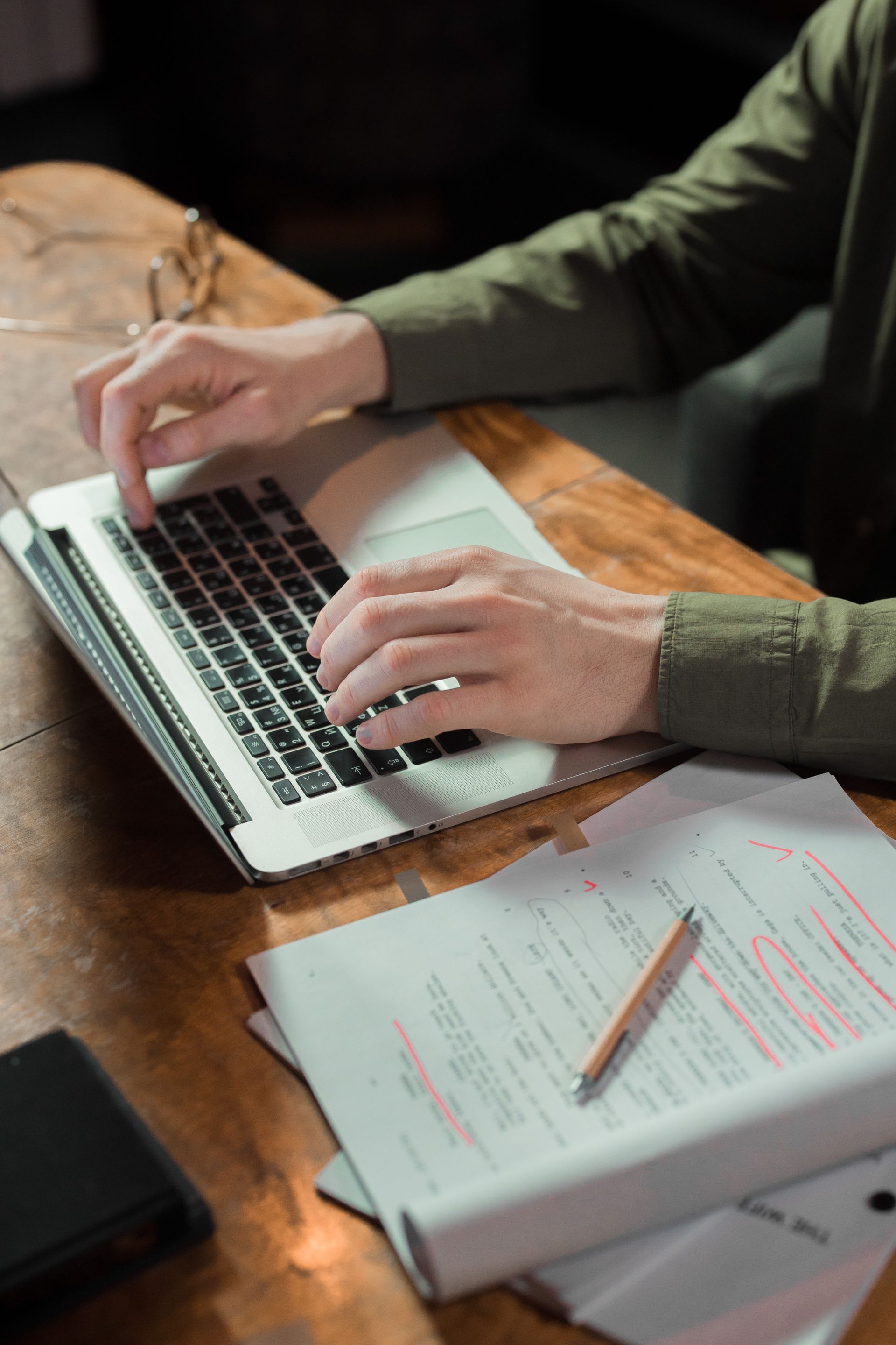 A writer drafting an article at a desk covered in notes