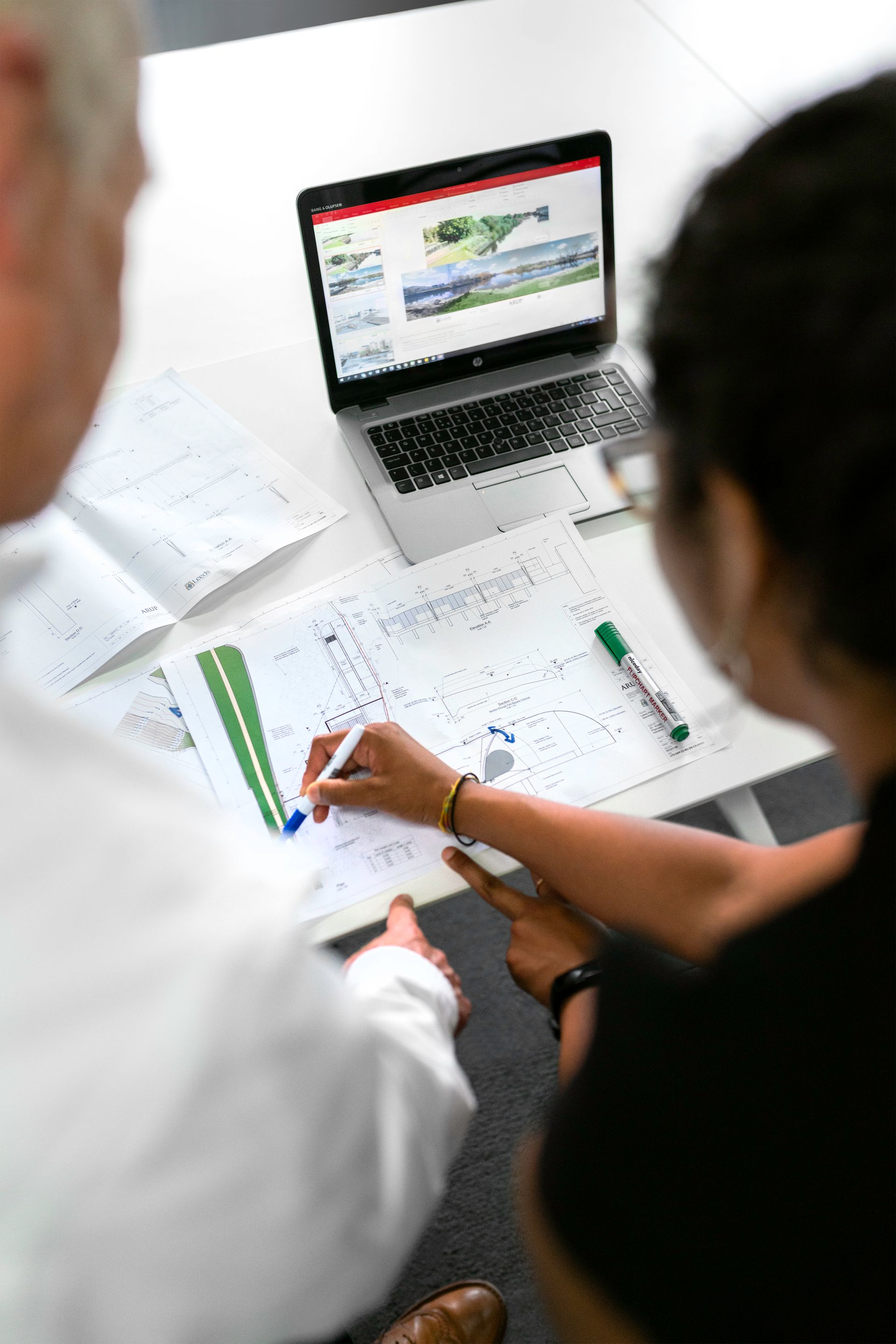 An engineer reviewing technical blueprints at a workbench