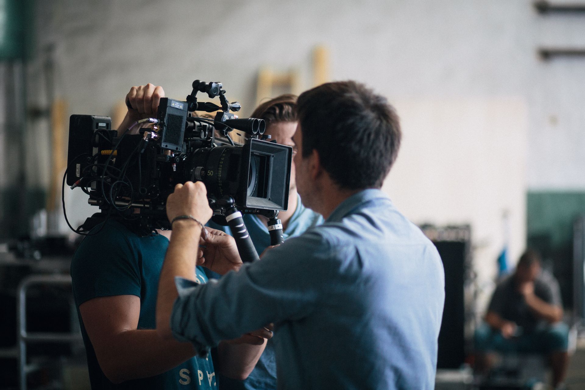 A film crew adjusting a professional video camera on an indoor set