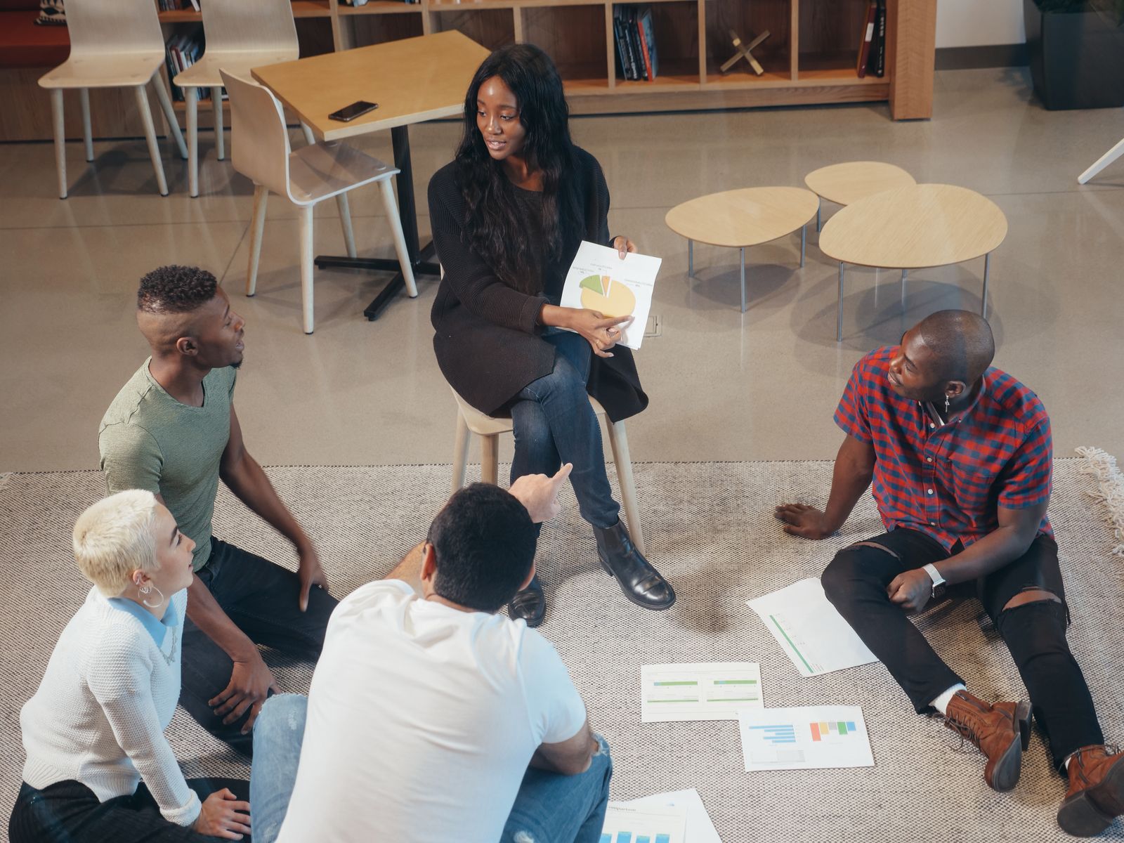 A team reading results together on the floor of a bright office