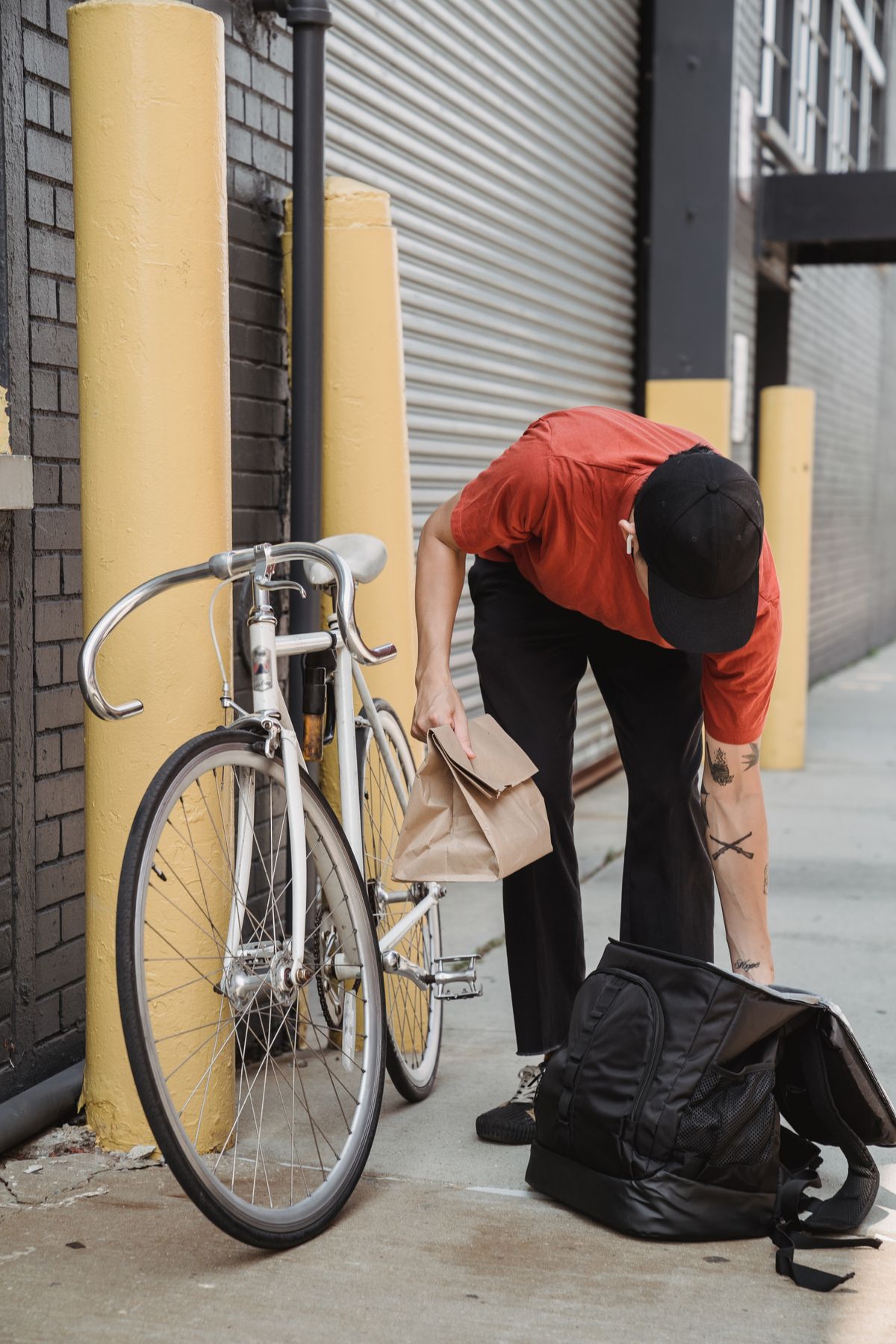 A courier packing a thermal bag next to his bicycle