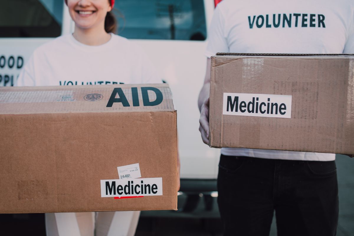 Volunteers holding boxes labelled AID and Medicine
