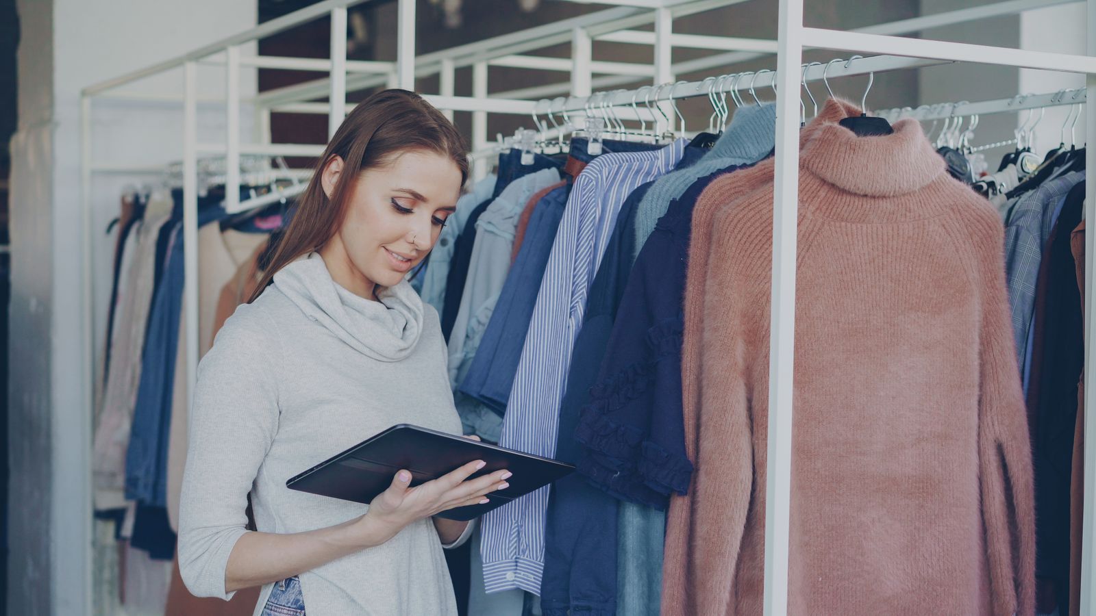 A shop associate managing inventory on a tablet